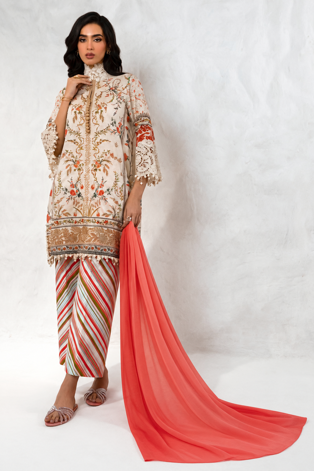 An embroidered ivory ensemble with a flowing coral dupatta
